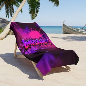 Empower Beach Towel Large, hanging over a lounge chair on a tropical beach