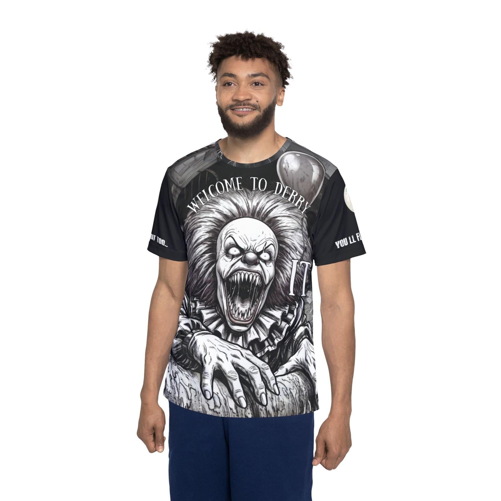 Front view of a premium all-over print t-shirt featuring a gritty, high-contrast black and white illustration of a terrifying, razor-toothed monster clown clawing its way forward. The arched text above reads "WELCOME TO DERRY" alongside a white graphic of the word "IT" and a floating balloon. The sleeves are solid black with white text.